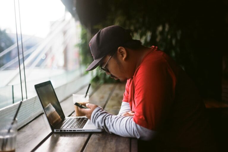 Muž pracuje na notebooku v kavárně – VPN na veřejné Wi-Fi
