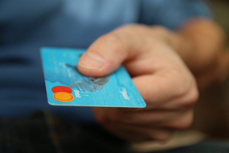 Ruka podává platební kartu – srovnání bankovních účtů